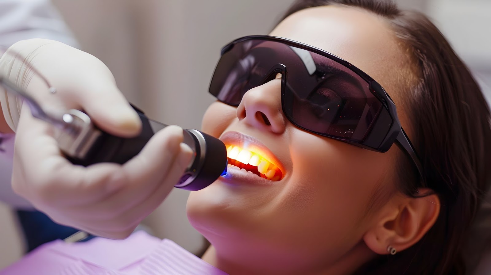 A woman receiving dental cleaning from a dentist, showcasing both traditional and laser dentistry techniques.