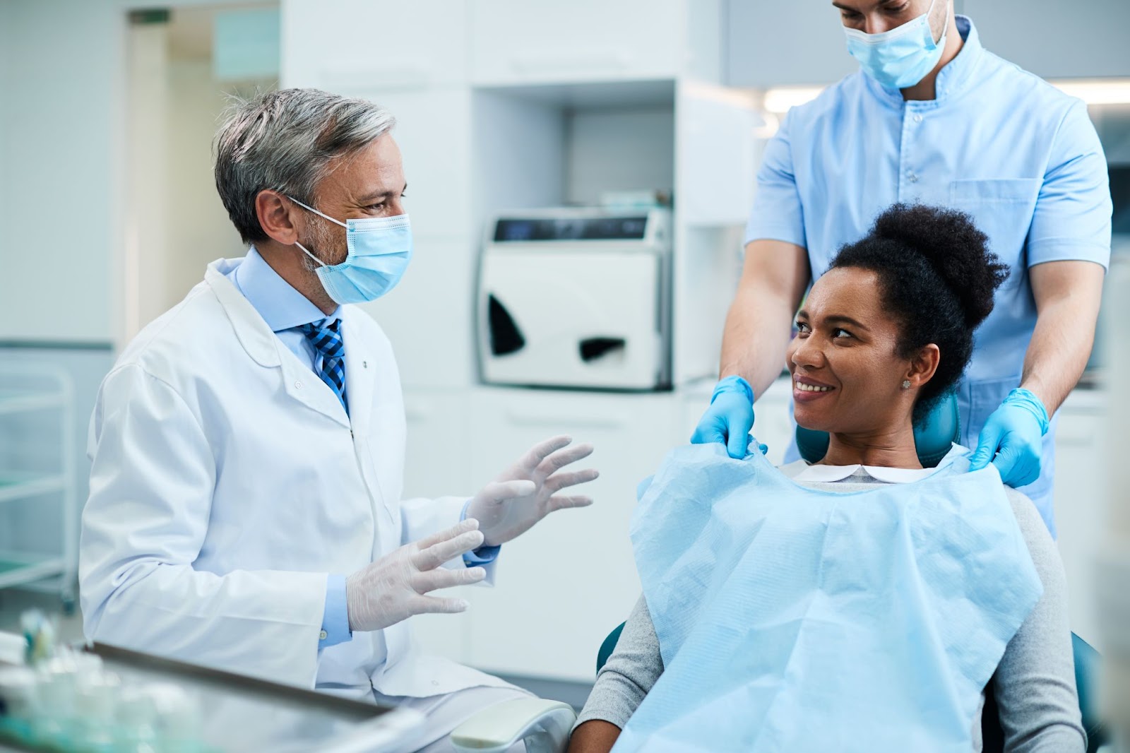 A man and woman consult in a dental office, discussing dental sealants to prevent tooth decay and cavities.