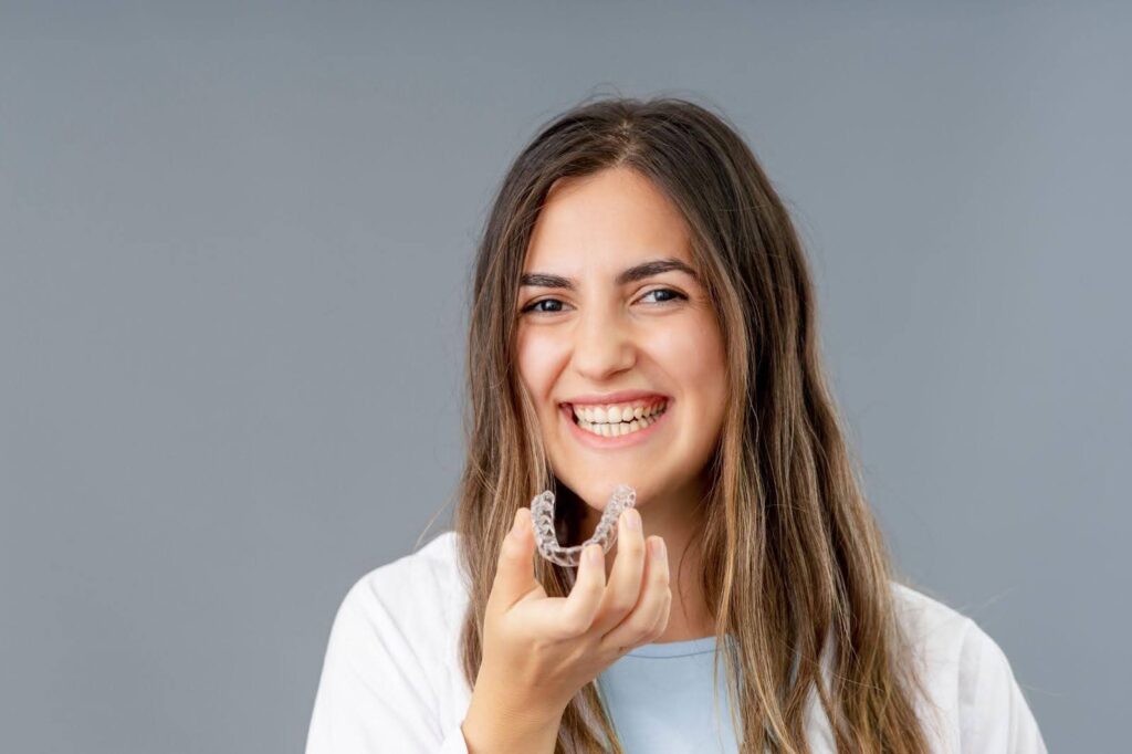 A woman confidently holds a toothbrush, ready for her dental routine